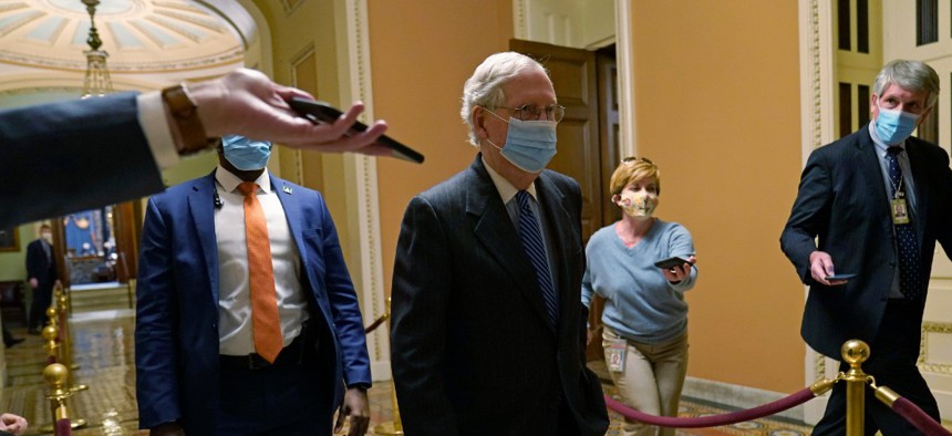 Senate Majority Leader Mitch McConnell of Ky., walks past reporters on Capitol Hill Dec. 15.