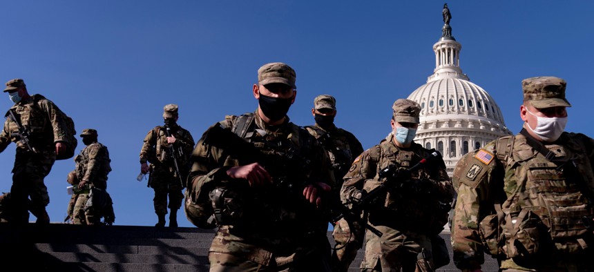 Members of the National Guard walk past the Dome of the Capitol Building on Capitol Hill in Washington Jan. 14.