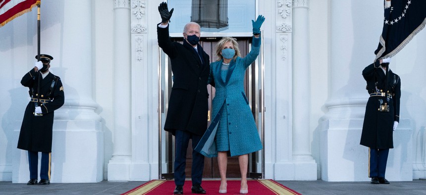 President Joe Biden and first lady Jill Biden wave as they arrive at the North Portico of the White House Jan. 20.