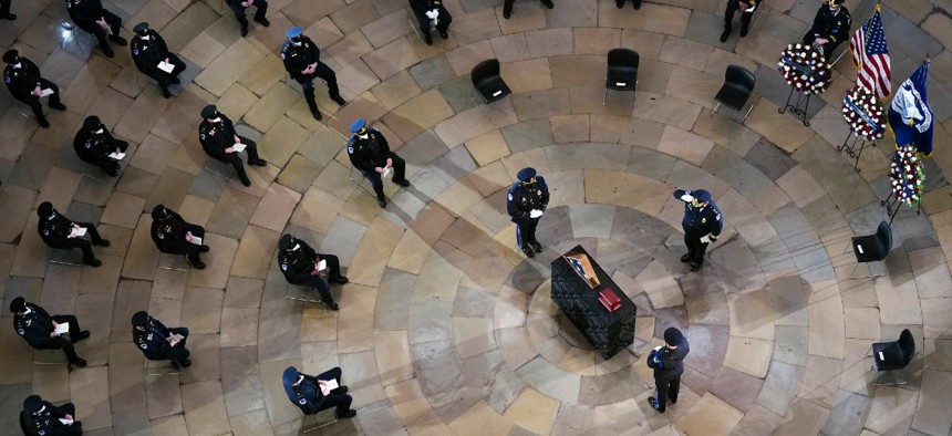 Mourners pay their respects during a ceremony memorializing U.S. Capitol Police officer Brian Sicknick, as an urn with his cremated remains lies in honor on a black-draped table at the center of the Capitol Rotunda Feb. 3.