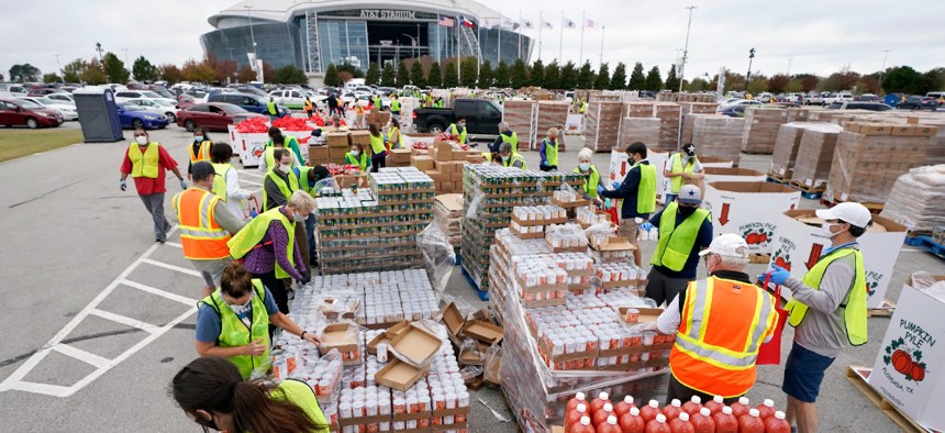 Volunteers build bags of dry goods in a parking lot outside of AT&T Stadium during a Tarrant Area Food Bank mobile pantry distribution event in Arlington, Texas in November.