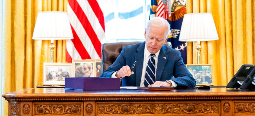 President Joe Biden signs the American Rescue Plan, a coronavirus relief package, in the Oval Office of the White House March 11.