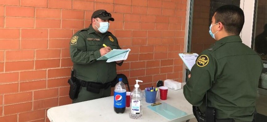 Customs and Border Protection Officer Perez checks in CBP Officer Flores at a Laredo, Texas, vaccination event.