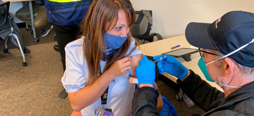 Grace John, who works at a school in San Lorenzo, gets a COVID-19 shot at a mobile vaccination clinic run by the Federal Emergency Management Agency and the state in Hayward, Calif., on Friday, Feb. 19, 2021.