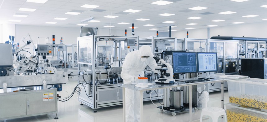 Shot of Sterile Pharmaceutical Manufacturing Laboratory where Scientists in Protective Coverall's Do Research, Quality Control and Work on the Discovery of new Medicine.