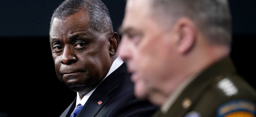 Defense Secretary Lloyd Austin, left, listens as Chairman of the Joint Chiefs of Staff Gen. Mark Milley, right, speaks during a briefing at the Pentagon in Washington, Thursday, May 6, 2021.