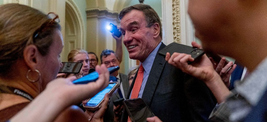 Sen. Mark Warner, D-Va., speaks to reporters after President Joe Biden met with Senate Democrats at the Capitol in Washington July 14.