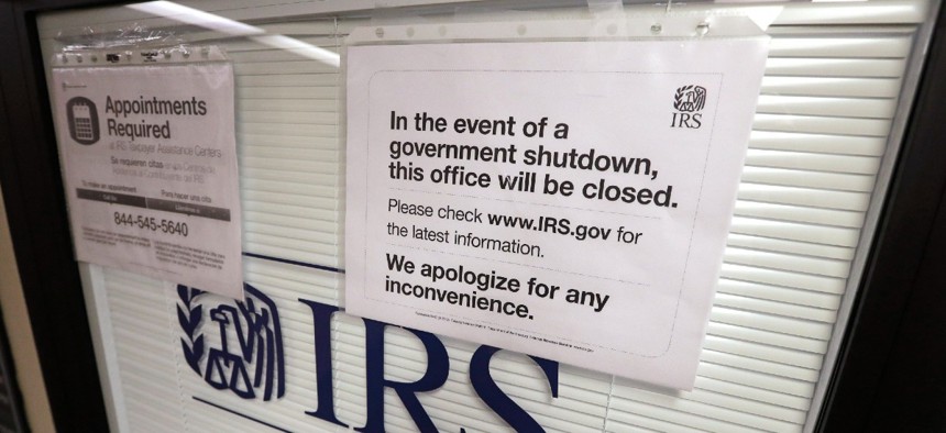 In this Jan. 16, 2019, file photo doors at the Internal Revenue Service (IRS) in the Henry M. Jackson Federal Building are locked and covered with blinds as a sign posted advises that the office will be closed during the partial government shutdown in Seattle. 