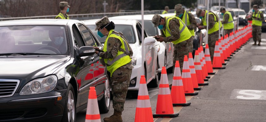 Members of the National Guard help motorists check in at a federally-run COVID-19 vaccination site set up on the campus of California State University of Los Angeles Feb. 16, 2021.