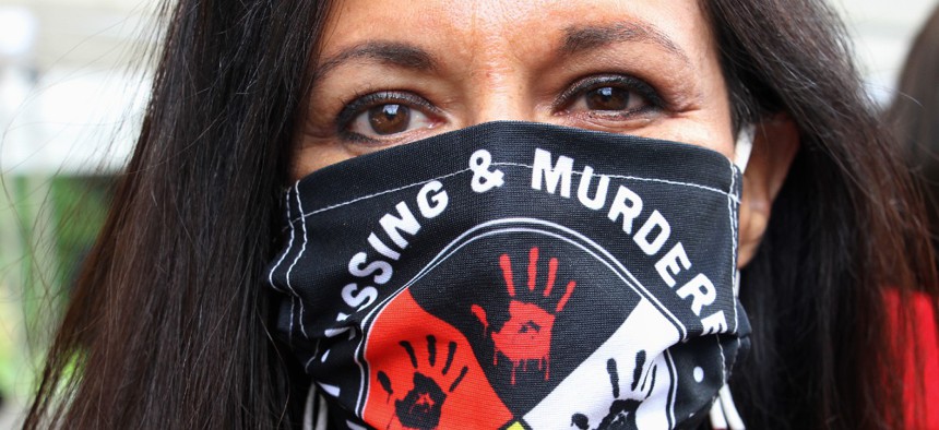 Jeannie Hovland, the deputy assistant secretary for Native American Affairs for the Department of Health and Human Services, poses with a Missing and Murdered Indigenous Women mask, in Anchorage, Alaska, Aug. 26, 2020. 