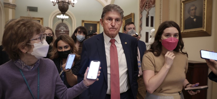 Sen. Joe Manchin (D-W. Va.) trailed by reporters after a meeting on Dec. 17, 2021