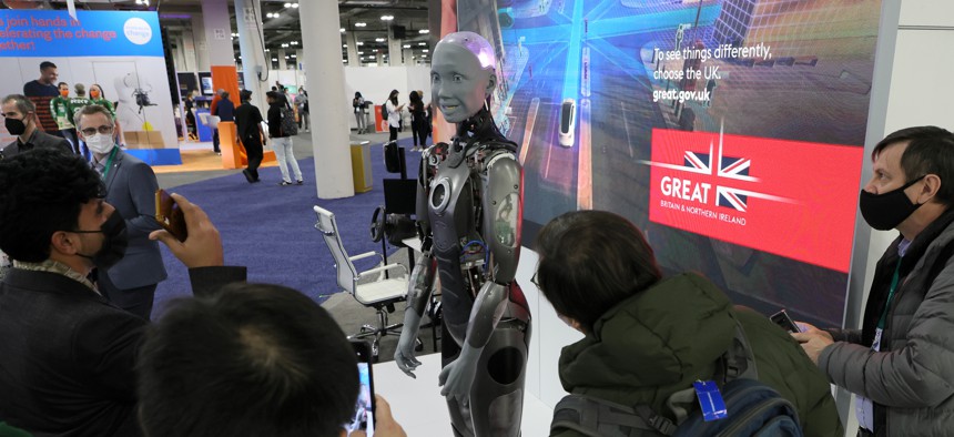 LAS VEGAS, NEVADA - JANUARY 05: Attendees look at an Ameca model humanoid robot by British company Engineered Arts at CES 2022 at The Venetian Las Vegas on January 5, 2022 in Las Vegas, Nevada.