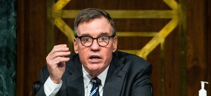 Chairman Sen. Mark Warner, D-Va, gives an opening statement as FireEye CEO Kevin Mandia, SolarWinds CEO Sudhakar Ramakrishna and Microsoft President Brad Smith testify at a Senate Intelligence Committee hearing on Capitol Hill on February 23, 2021.