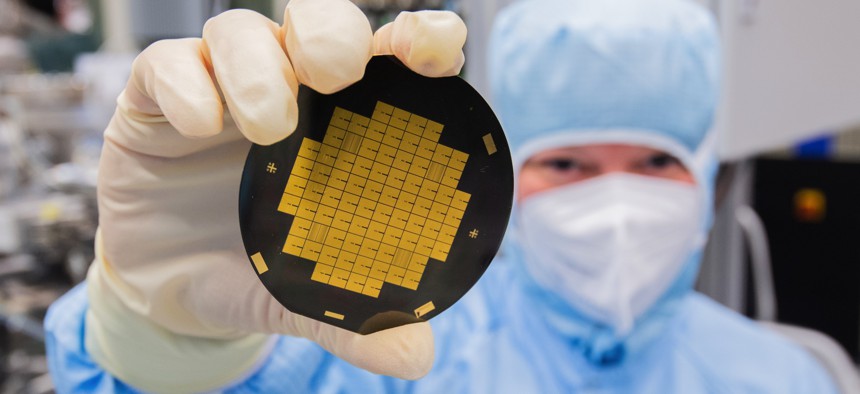 A research associate shows microchips for quantum processors in a clean room laboratory at the Physikalisch-Technische Bundesanstalt PTB in Braunschweig, Germany.