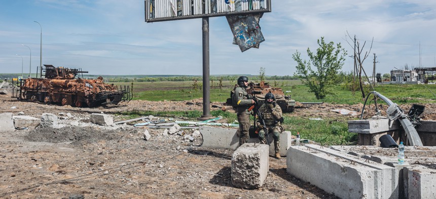 Two Ukrainian soldiers keep watch at a checkpoint in Kharkiv, Ukraine on May 12, 2022