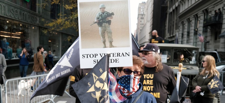 Families of soldiers who died by suicide hold signs in support of their loved ones during the Veterans Day Parade on Nov. 11, 2021 in New York City. 