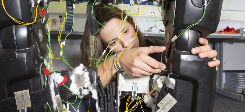 Female medical engineer working on a exoskeleton in the lab.