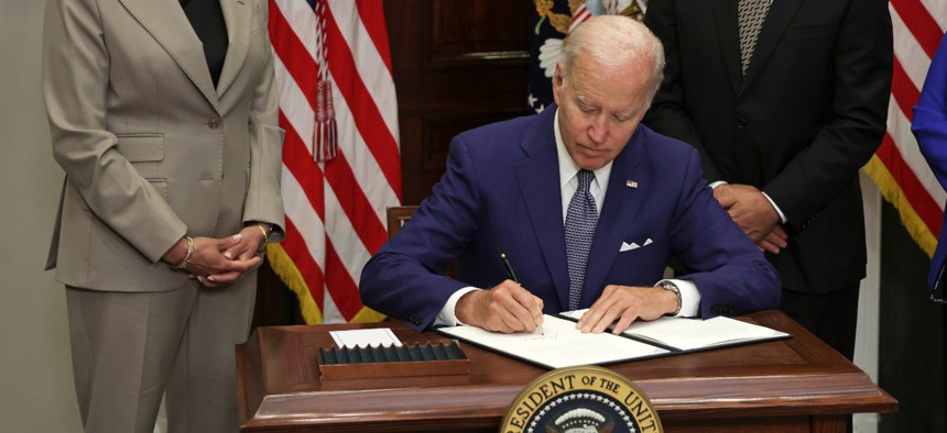 U.S. President Joe Biden signs an executive order on access to reproductive health care services as (L-R) Vice President Kamala Harris and Secretary of Health and Human Services Xavier Becerra look on during an event at the Roosevelt Room of the White House on July 8, 2022 in Washington, DC.