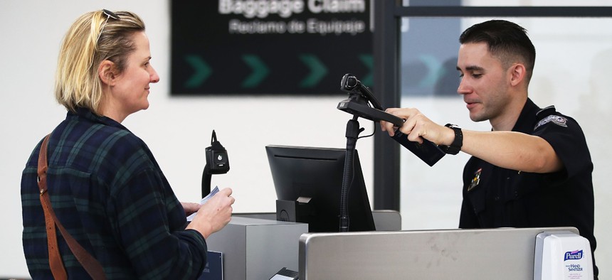 A U.S. Customs and Border Protection officer screens a traveler entering the United States using facial recognition technology at Miami International Airport  in February 2018.