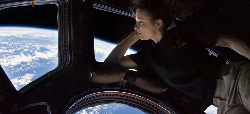 NASA astronaut Tracy Caldwell Dyson, Expedition 24 flight engineer, looks through a window in the Cupola of the International Space Station.