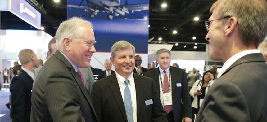 Chris Kubasik, CEO of L3Harris Technologies (center) and Air Force Secretary Frank Kendall (left) speak to Sean Stackley, L3Harris senior vice president for strategy and growth (right) at the Air and Space Forces Association's Air, Space & Cyber conference. 