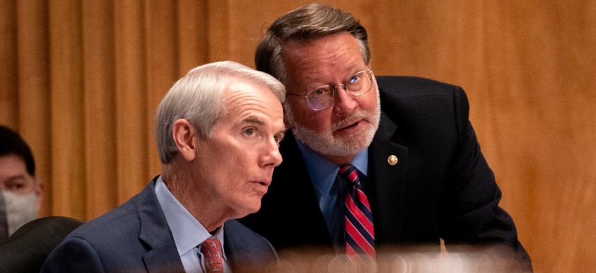 Sen. Rob Portman (R-OH) speaks to Sen. Gary Peters (D-MI) at a hearing to discuss security threats 20 years after the 9/11 terrorist attacks at the U.S. Capitol on September 21, 2021 in Washington, DC.