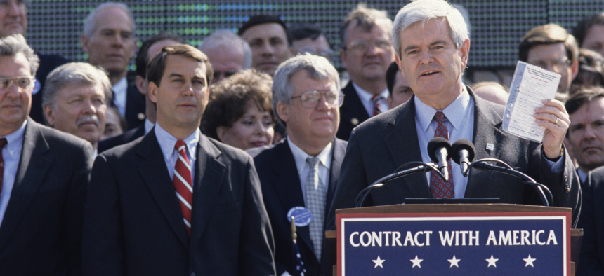 Newt Gingrich holds up a copy of the Contract With America at a ceremony marking the GOP's first 100 days in control of the House in 1995.
