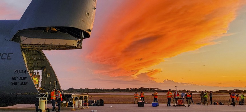 Airmen unload a satellite system from an Air Force C-5M Super Galaxy at Cape Canaveral Space Force Station, Fla., June 2, 2022.