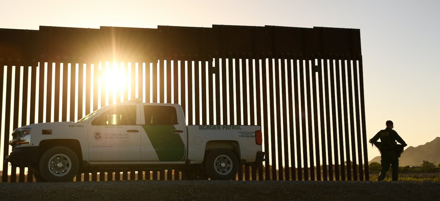 A Border Patrol agent walks between a gap along the border wall between the US and Mexico in Yuma, Arizona, on June 1, 2022. 