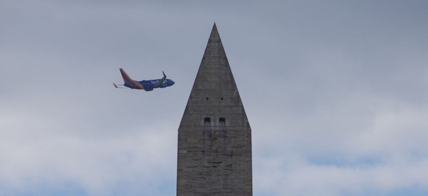 WASHINGTON D.C. , USA - DECEMBER 17: A plane flies over the Washington Monument as daily life continues in Washington D.C., United States on December 17, 2022