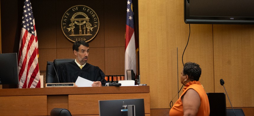 Fulton County Superior Court Judge Robert McBurney receives documents from County Court Clerk Che Alexander on August 14, 2023 in Atlanta, Georgia. 