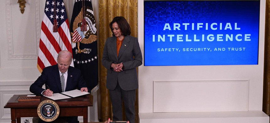 President Joe Biden signs an executive order on artificial intelligence in the East Room of the White House on Oct. 30, 2023, as Vice President Kamala Harris looks on.