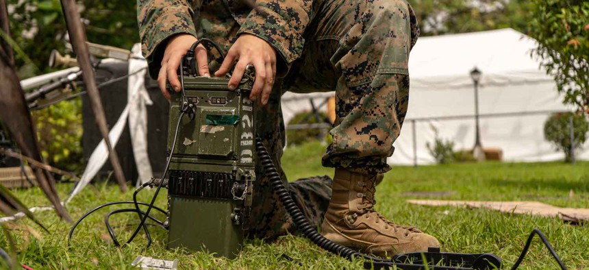Cpl. Eniya Yanina, a radio operator with Marine Rotational Force-Southeast Asia, configures a radio in preparation for an exercise on Fort Bonifacio, Philippines, Nov. 7, 2023.