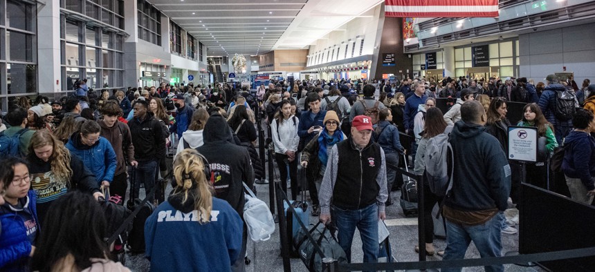 Holiday travelers crowd Boston's Logan Airport on Dec. 21, 2023.