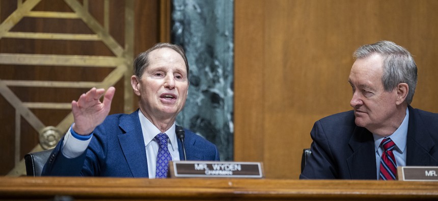 Sens. Ron Wyden, D-Ore., (L) and Mike Crapo, R-Ida., shown here leading a Finance committee hearing in February 2023, are backing legislation to retool the unemployment insurance system.