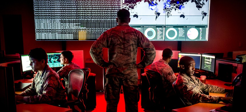 Capt. Taiwan Veney, cyber warfare operations officer, watches members of the 175th Cyberspace Operations Group analyze log files and provide a cyber threat update at Warfield Air National Guard Base, Middle River, Md., June 3, 2017.