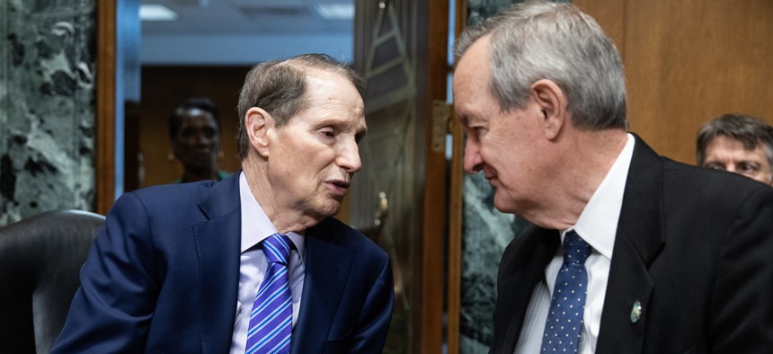Chairman Ron Wyden, D-Ore., left, and ranking member Sen. Mike Crapo, R-Idaho, talk before a Senate Finance Committee hearing. The lawmakers introduced legislation Wednesday aimed at improving the unemployment insurance program.