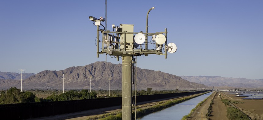 A Customs and Border Protection surveillance tower monitors activity along the U.S.-Mexico border fence and the All-American Canal in Calexico, Calif. Lawmakers are looking to augment border surveillance with AI capabilities.