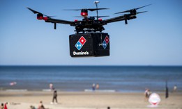 A drone delivers pizza to a beach as part of a 2020 test in the Netherlands. New U.S. spectrum rules supporting drone navigation will give operators access to communications to support more use cases of this kind in the future.