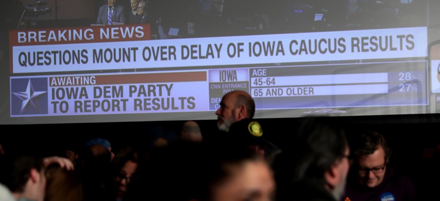 A CNN broadcast at a 2020 Iowa Caucus watch party for Sen. Bernie Sanders notes ongoing delays of the results of the vote. 