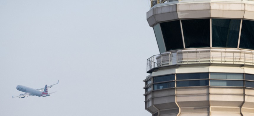 An American Airlines Airbus A321 airplane takes off past the air traffic control tower at Ronald Reagan Washington National Airport in Arlington, Va. A coming oversight report examines the use of legacy technology in Federal Aviation Administration operations.