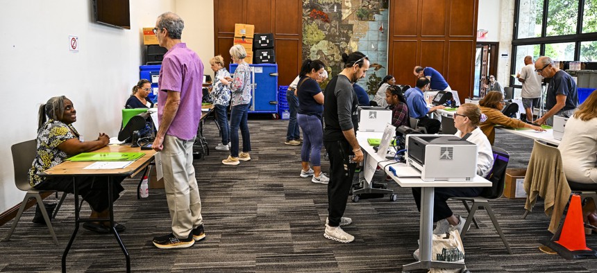 Voters cast their ballots in a public library in Coral Gables, Fla. on Oct. 21. Cyber researchers are keeping close tabs on efforts by foreign adversaries to influence the election using AI-generated content.