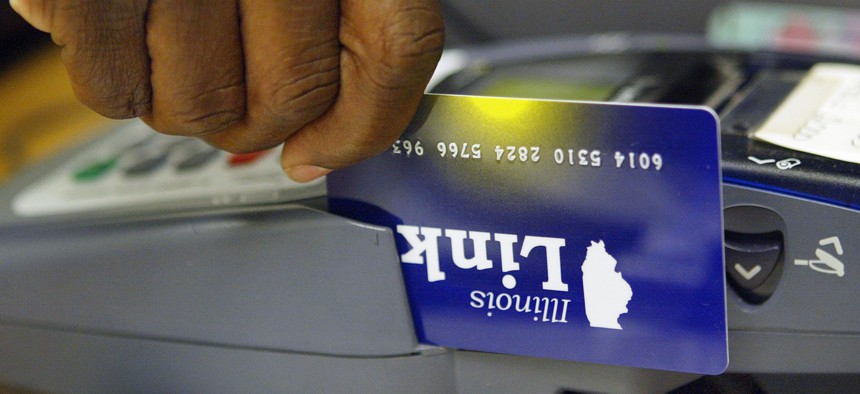 An Illinois Department of Human Services office clerk demonstrates the activation of an Illinois Link card. The federal reimbursements available for such cards that have been skimmed and had benefits stolen could end Dec. 20 without legislation to extend the program.