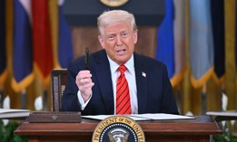 President Donald Trump holds up a pen as he signs an executive order during an education event in the East Room of the White house in Washington, DC, March 20, 2025. 