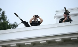 Members of the Secret Service's counter sniper team look out from the roof of the West Wing of the White House on August 5, 2025.