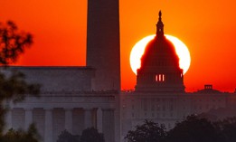 The sun rises behind the U.S. Capitol Dome with the Lincoln Memorial, left, and Washington Monument, center, in Washington, DC, as seen from the Netherlands Carillon on September 19, 2025, in Arlington, VA. 