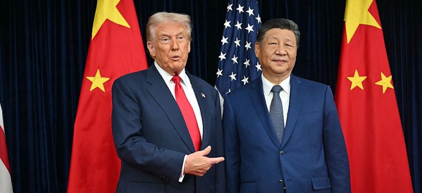 President Donald Trump and China's President Xi Jinping greet each other as they arrive for talks at the Gimhae Air Base in Busan on October 30, 2025.