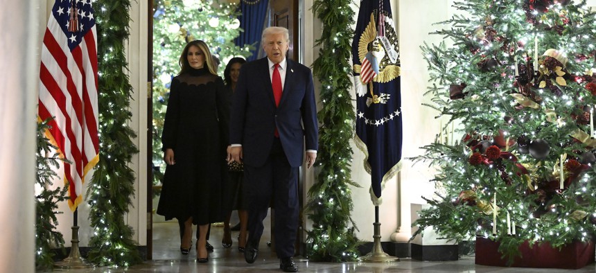 President Donald Trump and first lady Melania walk among Christmas decorations en route to the East Room at the White House on Dec. 5, 2025, where Andrea Bocelli performed a concert for them.