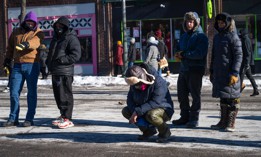 A person kneels near the site where 37-year-old Alex Pretti was allegedly shot and killed by federal agents on Jan. 24, 2026 in Minneapolis, Minnesota. Federal agents allegedly shot and killed Pretti, a south Minneapolis resident, amid a scuffle to arrest him. 