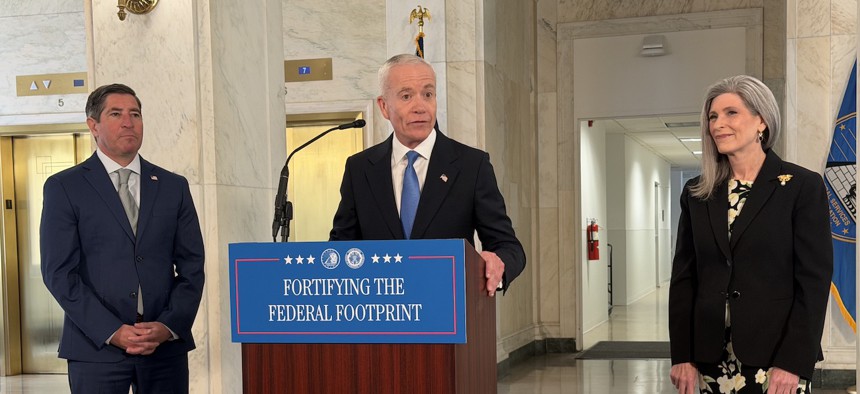 GSA Administrator Ed Forst, flanked by OPM Director Scott Kupor and Sen. Joni Ernst, R-Iowa, announces a relocation of his agency during a press conference on April 20.